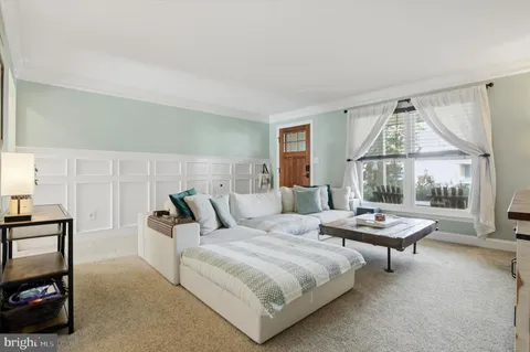 a bedroom with a bed a table and large window