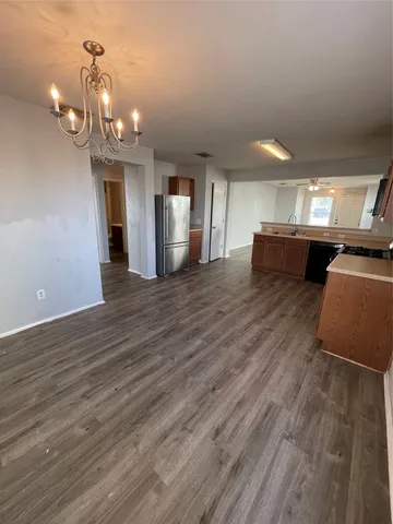a view of a room with wooden floor and kitchen view