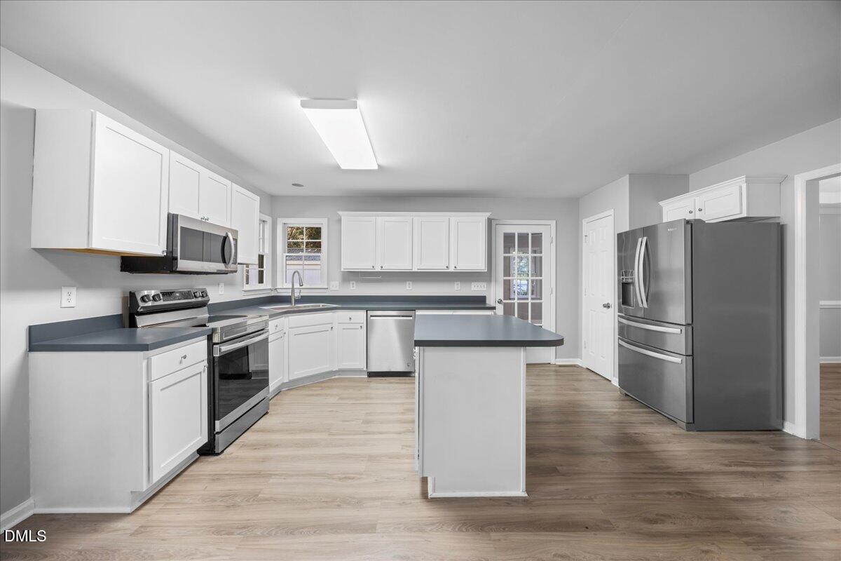 2708 Ferrand Drive Durham, NC 27705 - Photo 10 of 47 a kitchen with a refrigerator cabinets and wooden floor