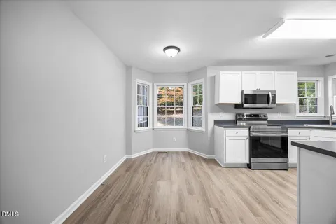 a kitchen with granite countertop a refrigerator stove top oven and sink