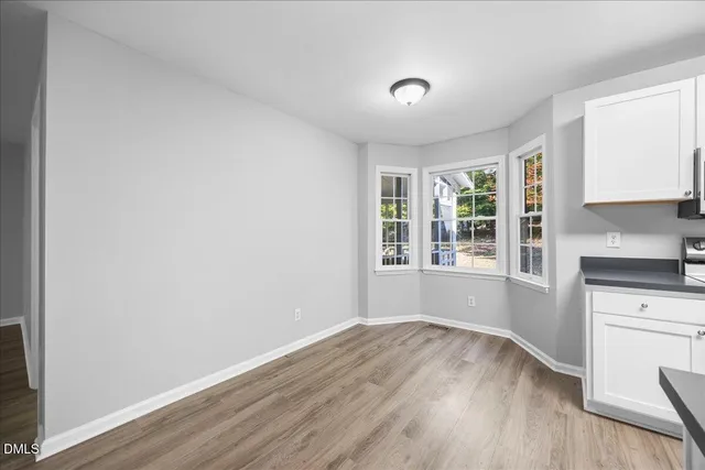 a kitchen with a refrigerator cabinets and wooden floor