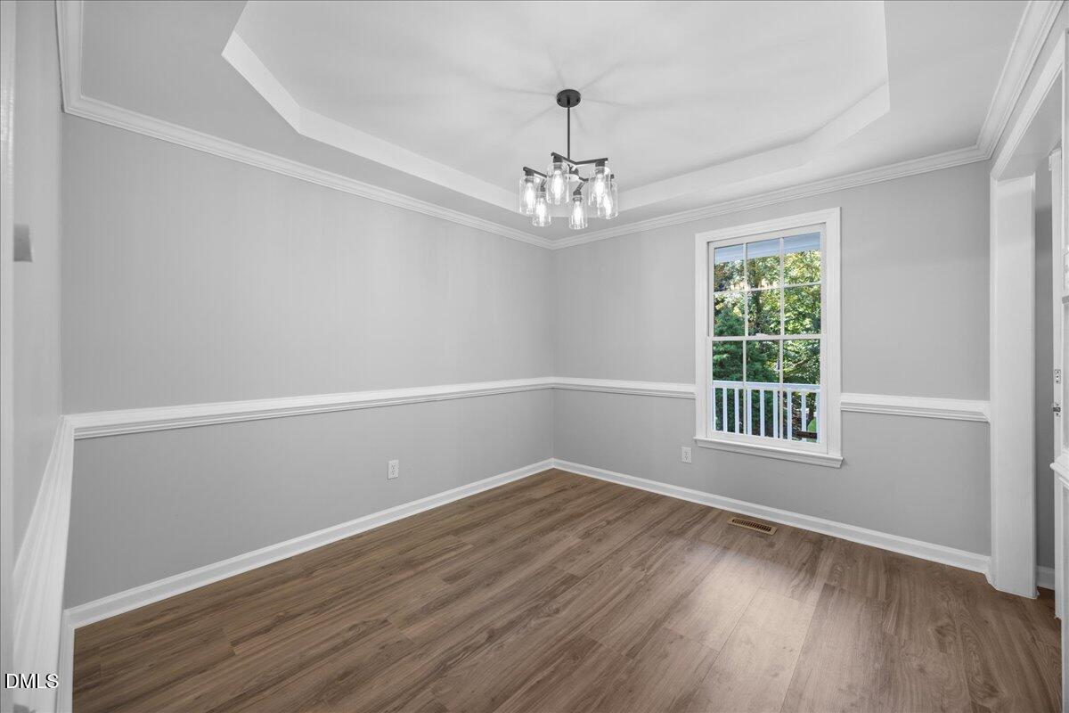 2708 Ferrand Drive Durham, NC 27705 - Photo 13 of 47 a view of an empty room with wooden floor and a window