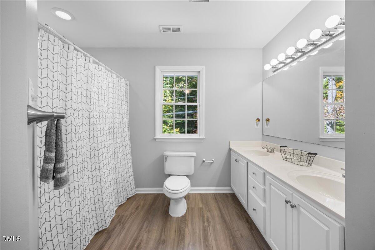 2708 Ferrand Drive Durham, NC 27705 - Photo 23 of 47 a spacious bathroom with a double vanity sink a toilet and a shower