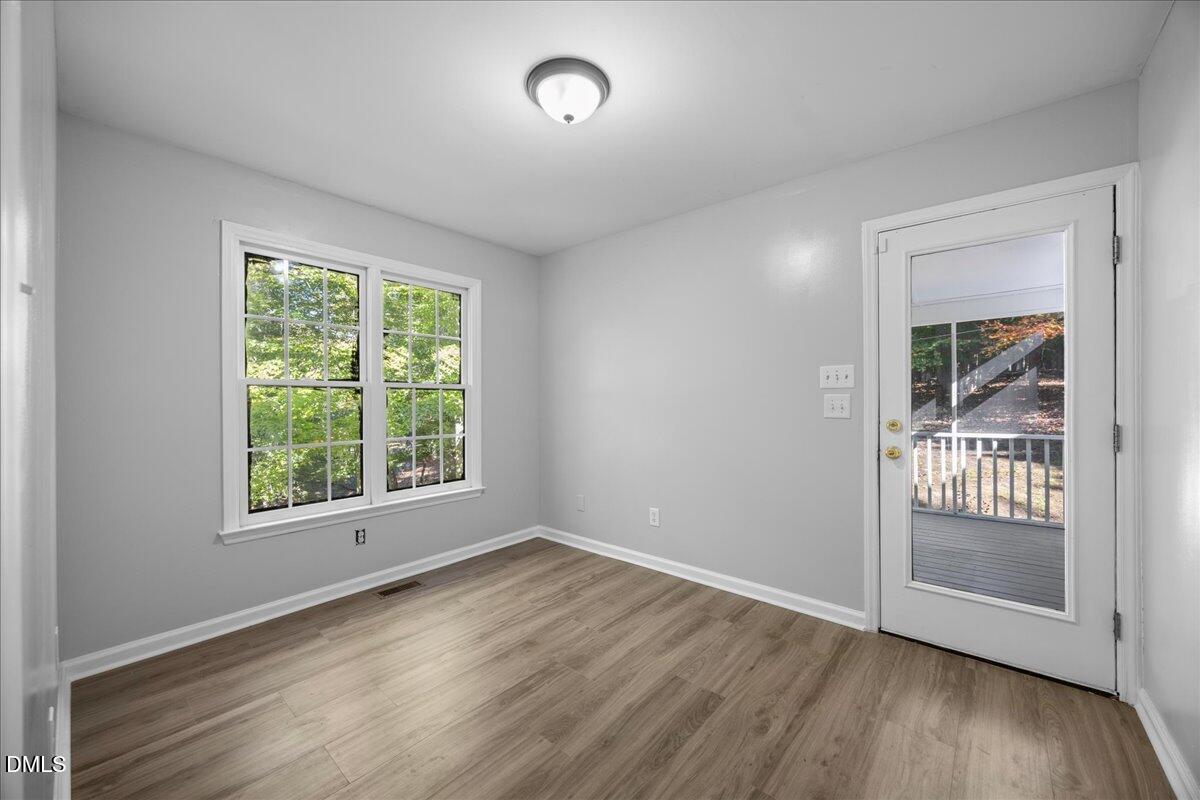2708 Ferrand Drive Durham, NC 27705 - Photo 8 of 47 an empty room with wooden floor and windows