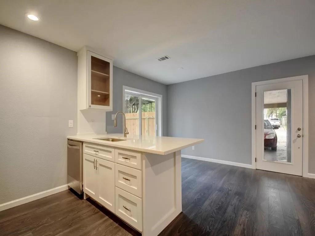 a kitchen with a stove and wooden floor