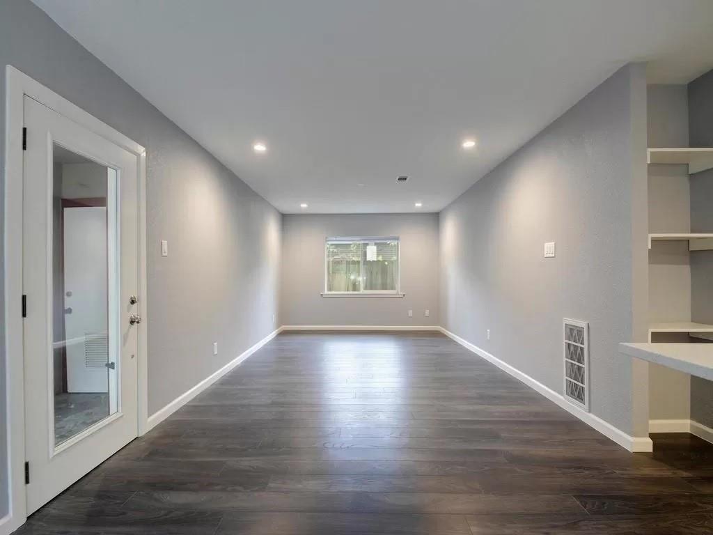 4702 Duval Street Austin, TX 78751 - Photo 7 of 20 a view of an empty room with wooden floor and a window