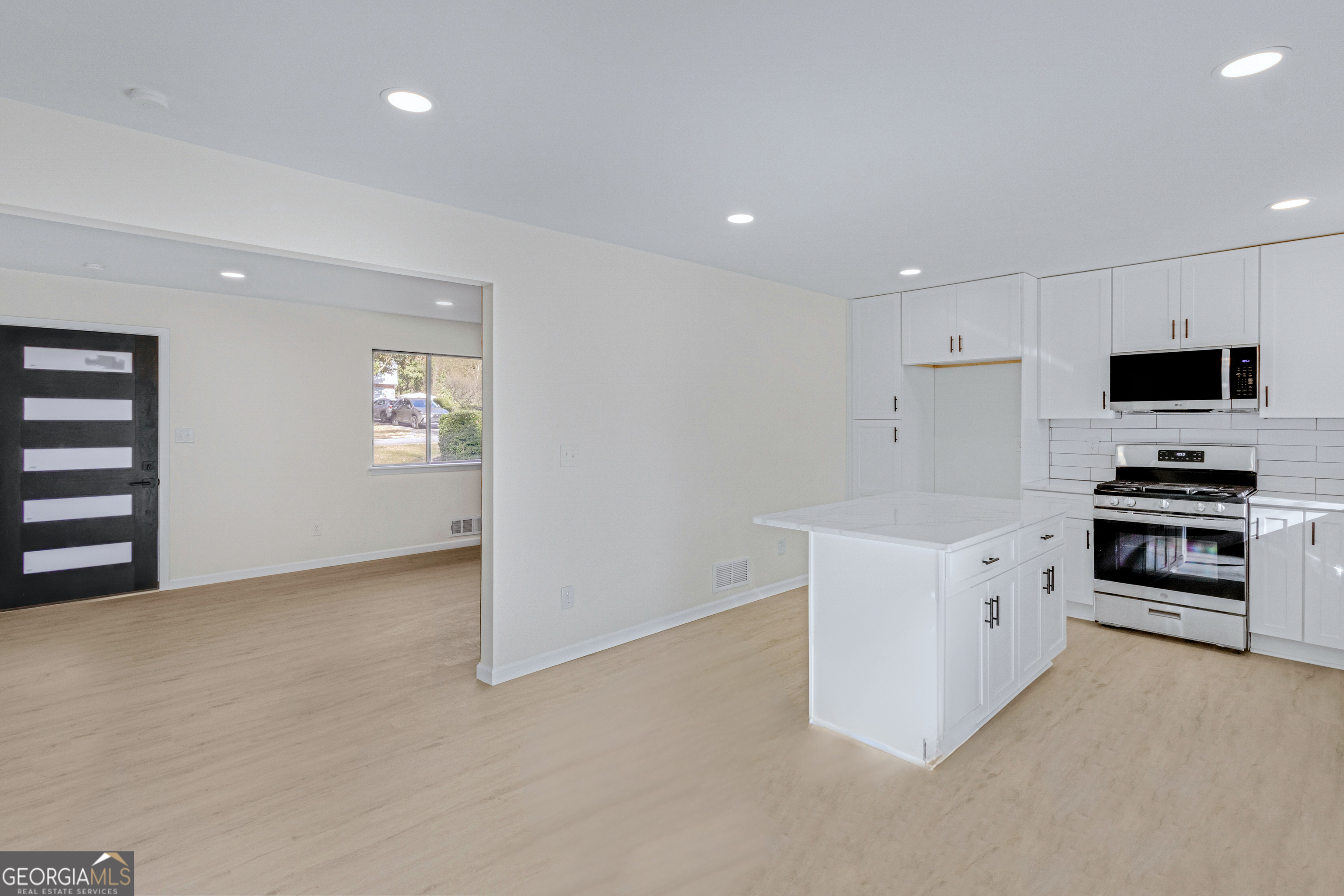 6695 Cedar Hurst Trail Atlanta, GA 30349 - Photo 8 of 23 a kitchen with granite countertop a refrigerator and a stove top oven
