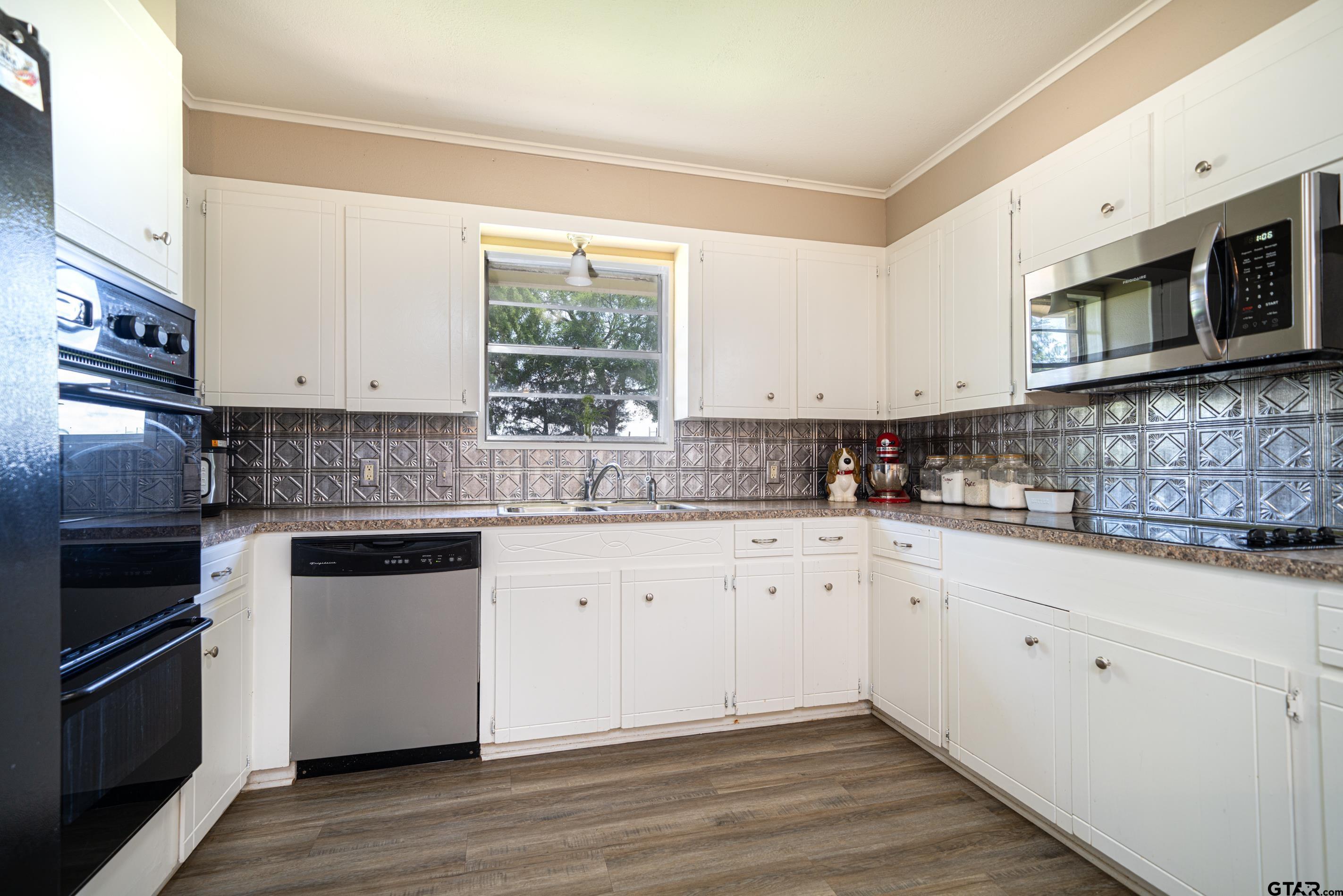 2536 Elk Road Gilmer, TX 75644 - Photo 11 of 32 a kitchen with stainless steel appliances granite countertop a stove a sink and a microwave