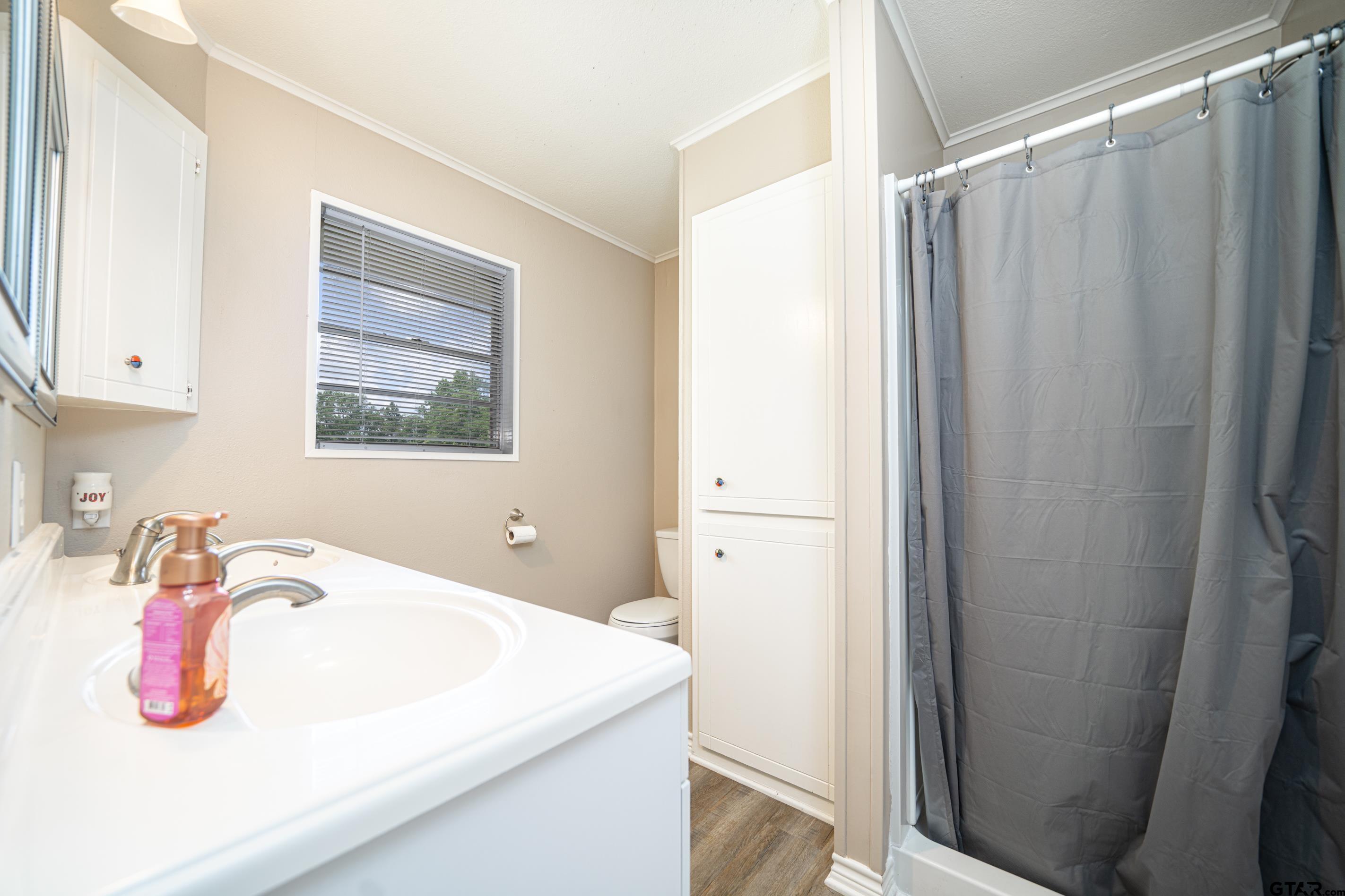 2536 Elk Road Gilmer, TX 75644 - Photo 15 of 32 a bathroom with a sink a mirror and vanity