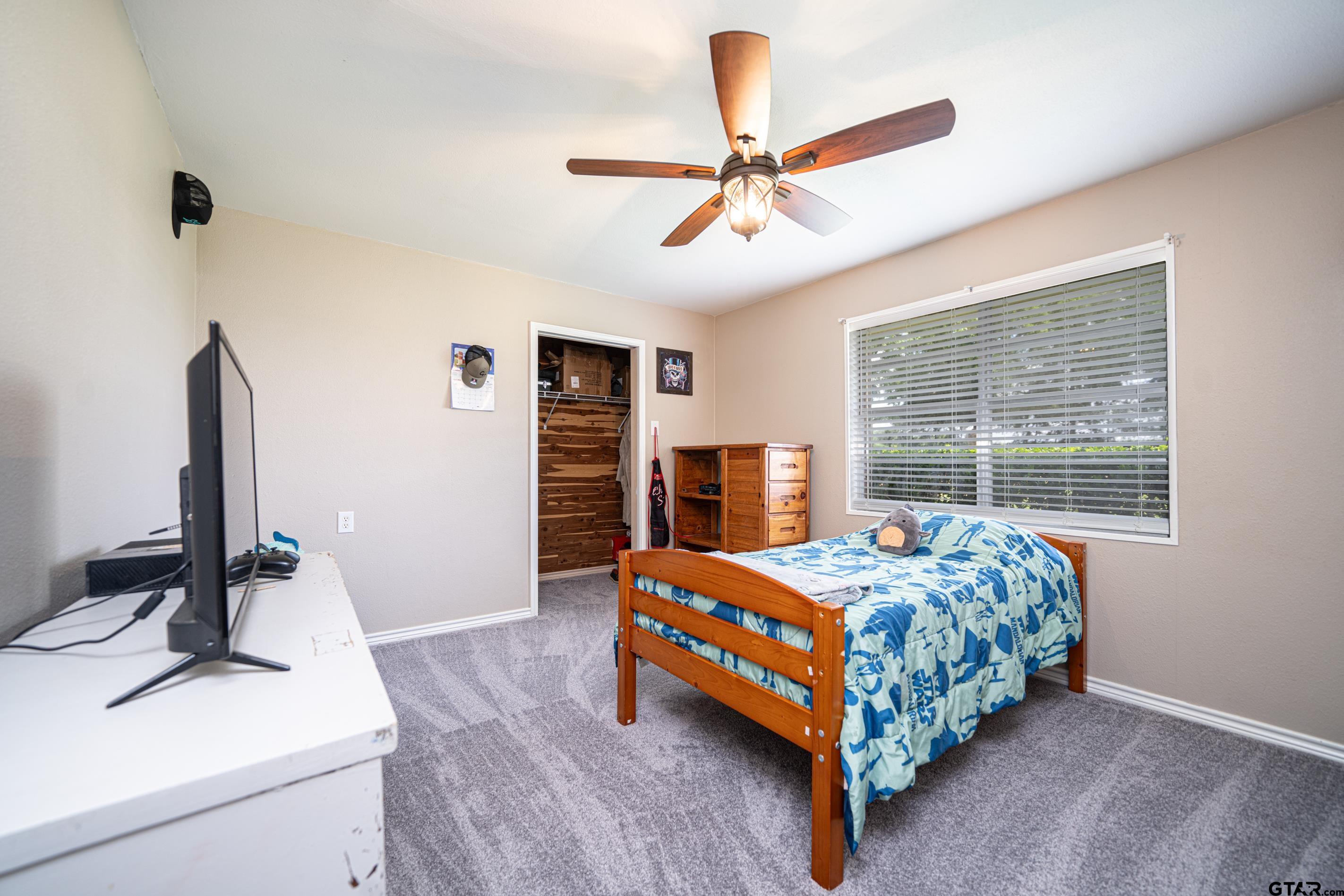 2536 Elk Road Gilmer, TX 75644 - Photo 18 of 32 a bedroom with a bed and a chandelier