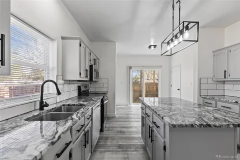 a kitchen with stainless steel appliances granite countertop a sink stove and cabinets