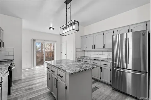 a kitchen with stainless steel appliances granite countertop a refrigerator and a sink