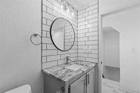 a bathroom with a granite countertop sink and a mirror