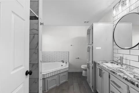 a bathroom with a granite countertop sink toilet and shower