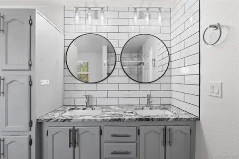 a bathroom with a granite countertop sink and a mirror
