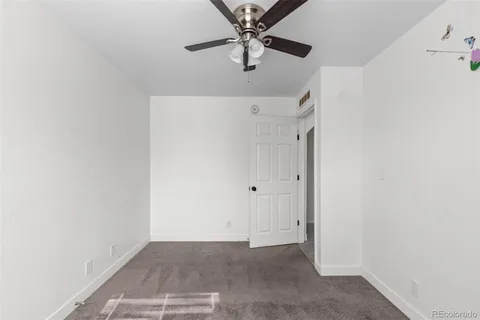 a view of a hallway with a chandelier fan