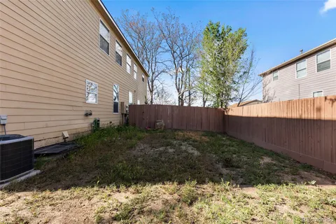a view of backyard with wooden fence and trees
