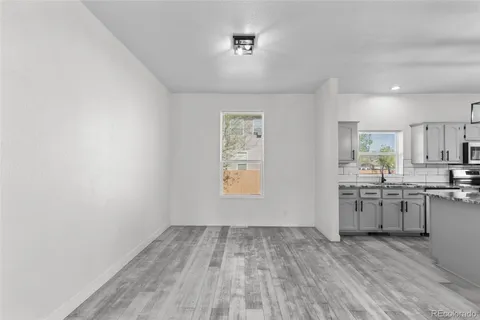 a view of kitchen with wooden floor sink and electronic appliances