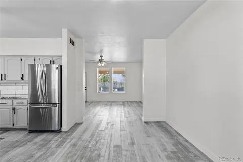 a view of kitchen with wooden floor electronic appliances and cabinets