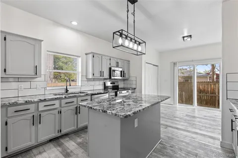a kitchen with stainless steel appliances granite countertop a sink and dishwasher with white cabinets