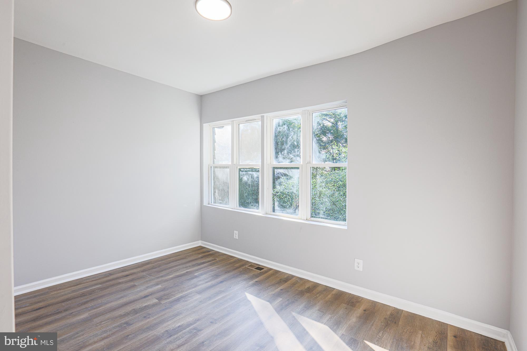 2606 Queen Anne Road Baltimore, MD 21216 - Photo 46 of 92 an empty room with wooden floor and windows
