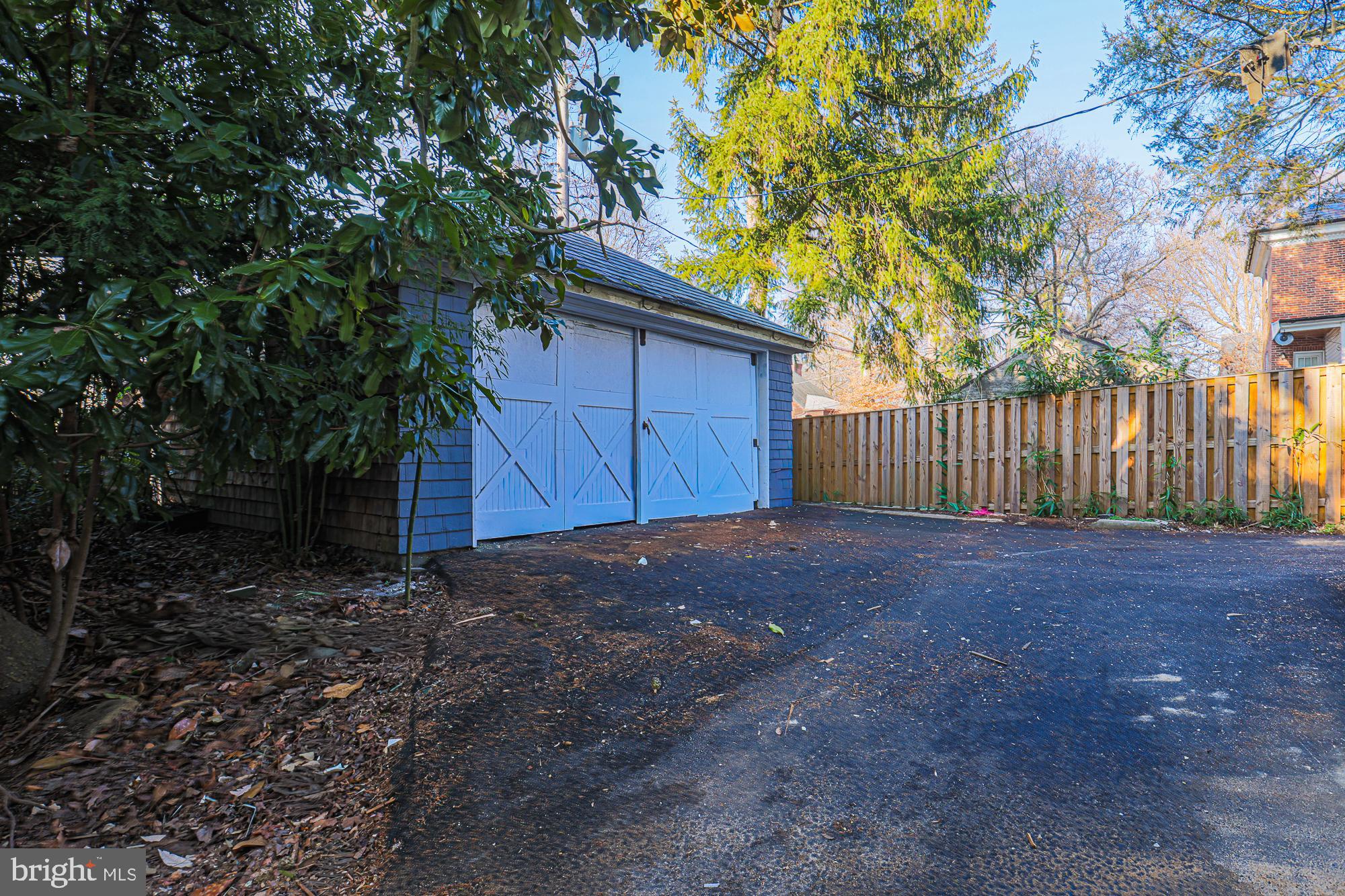 2606 Queen Anne Road Baltimore, MD 21216 - Photo 6 of 92 a view of a backyard with large trees and wooden fence