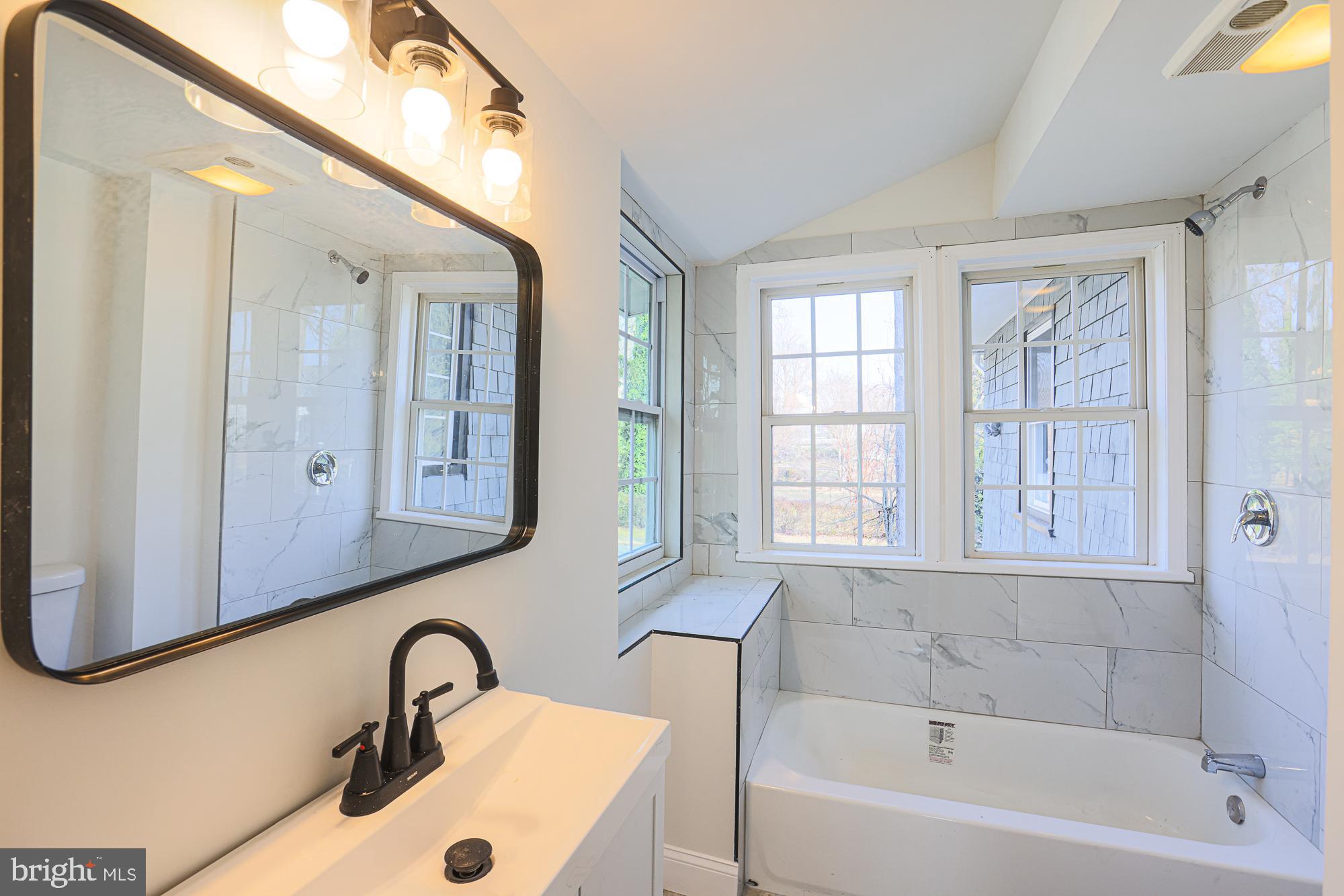 2606 Queen Anne Road Baltimore, MD 21216 - Photo 59 of 92 a bathroom with a sink a mirror and a bathtub
