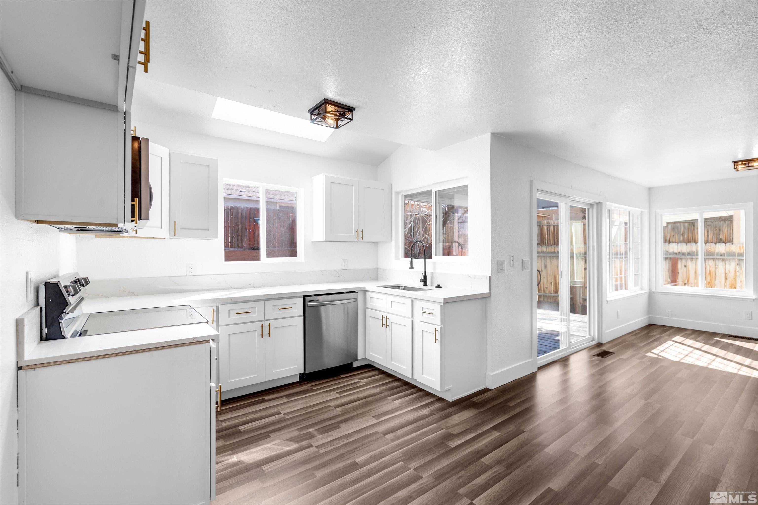 6768 Peppermint Court Reno, NV 89506 - Photo 13 of 40 a kitchen with granite countertop white cabinets and white appliances