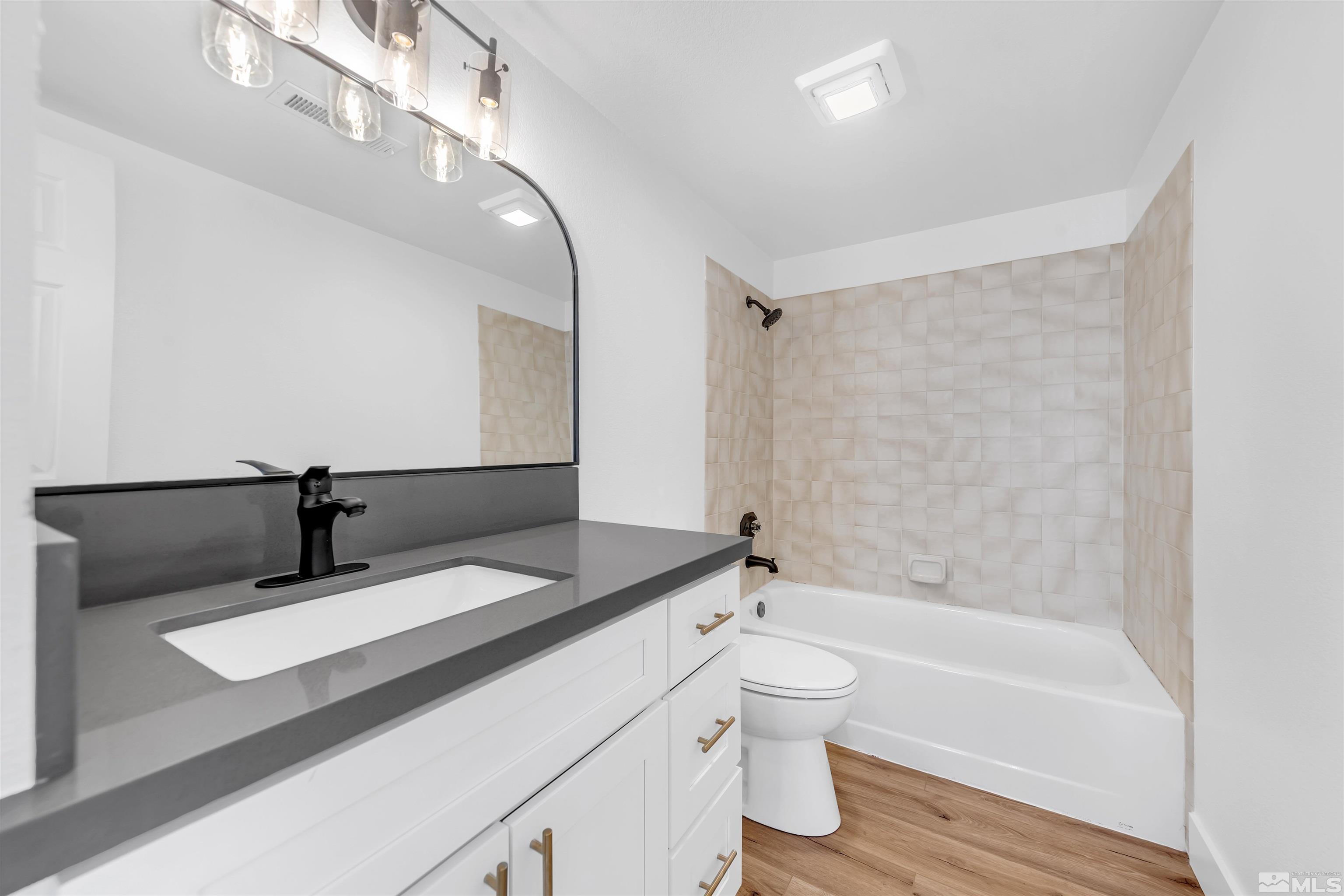 6768 Peppermint Court Reno, NV 89506 - Photo 30 of 40 a bathroom with a bathtub shower sink vanity and toilet