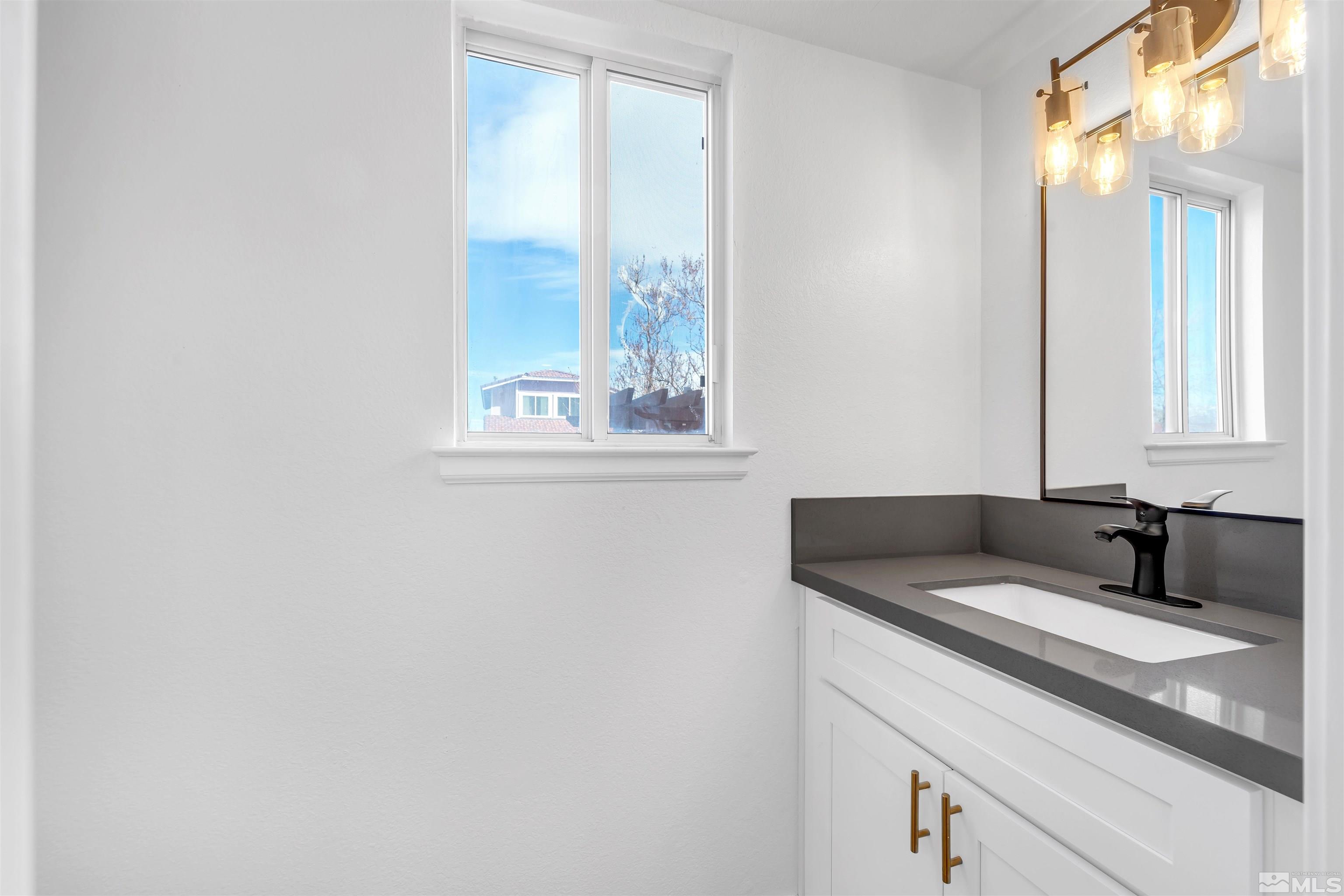 6768 Peppermint Court Reno, NV 89506 - Photo 33 of 40 a bathroom with a granite countertop sink and a mirror