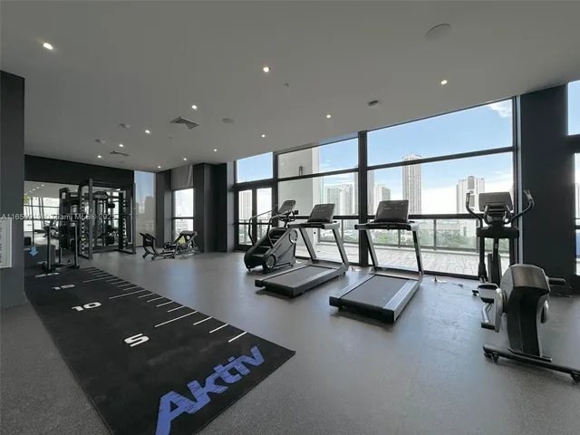 a living room with gym equipment and a large window
