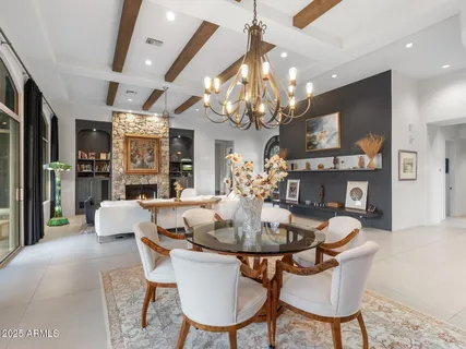 a large kitchen with kitchen island a sink a stove a dining table and a large window with the wooden floor