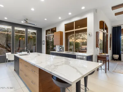 a bedroom with a bed and large windows