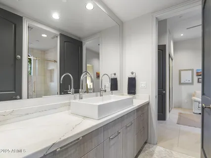 a bedroom with a bed and large windows