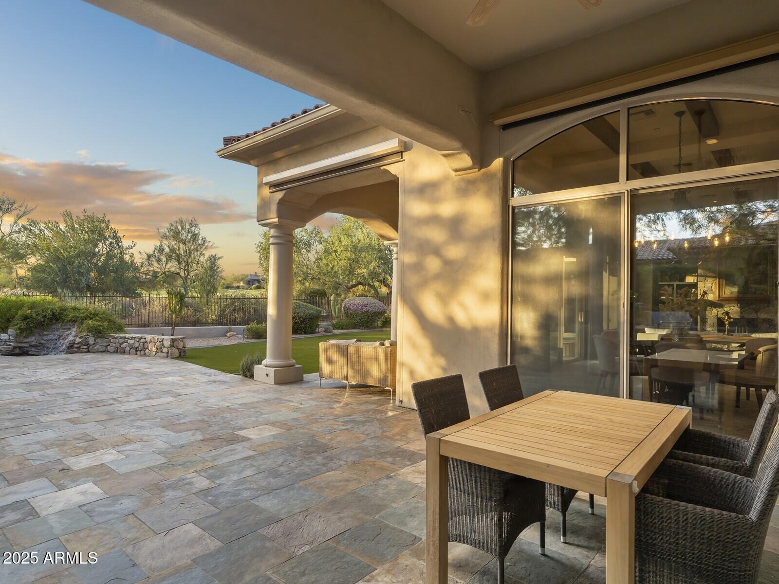 9290 East Thompson Peak Parkway, Unit 142 Scottsdale, AZ 85255 - Photo 43 of 74 a view of a patio with table and chairs with wooden floor and fence