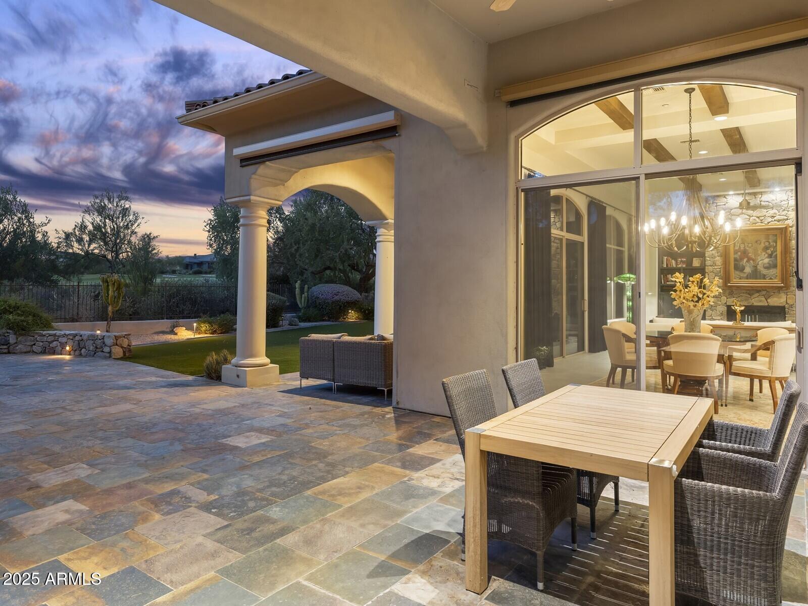 9290 East Thompson Peak Parkway, Unit 142 Scottsdale, AZ 85255 - Photo 49 of 74 a view of a patio with a table chairs and a floor to ceiling window