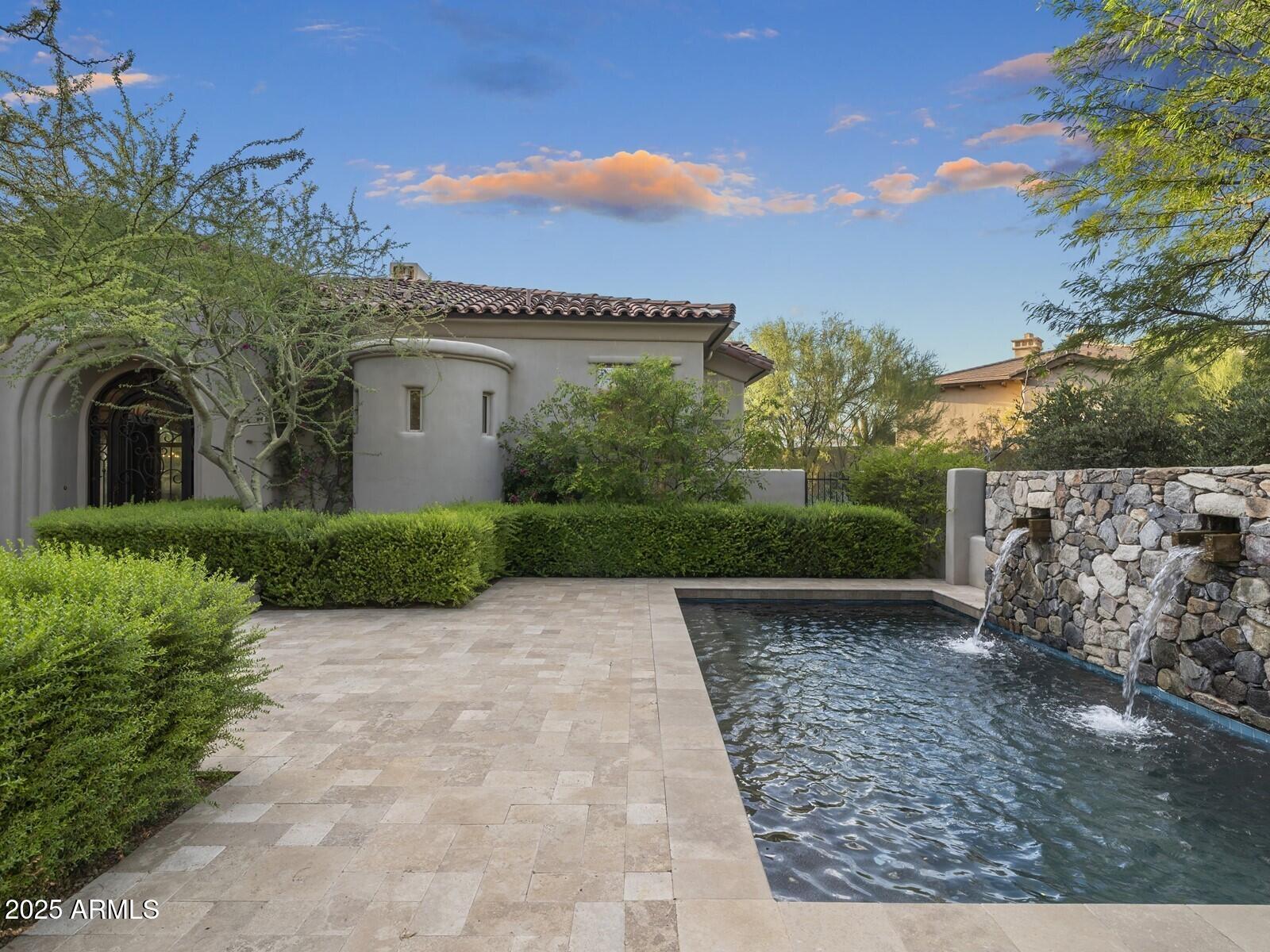 9290 East Thompson Peak Parkway, Unit 142 Scottsdale, AZ 85255 - Photo 5 of 74 a front view of a house with a garden