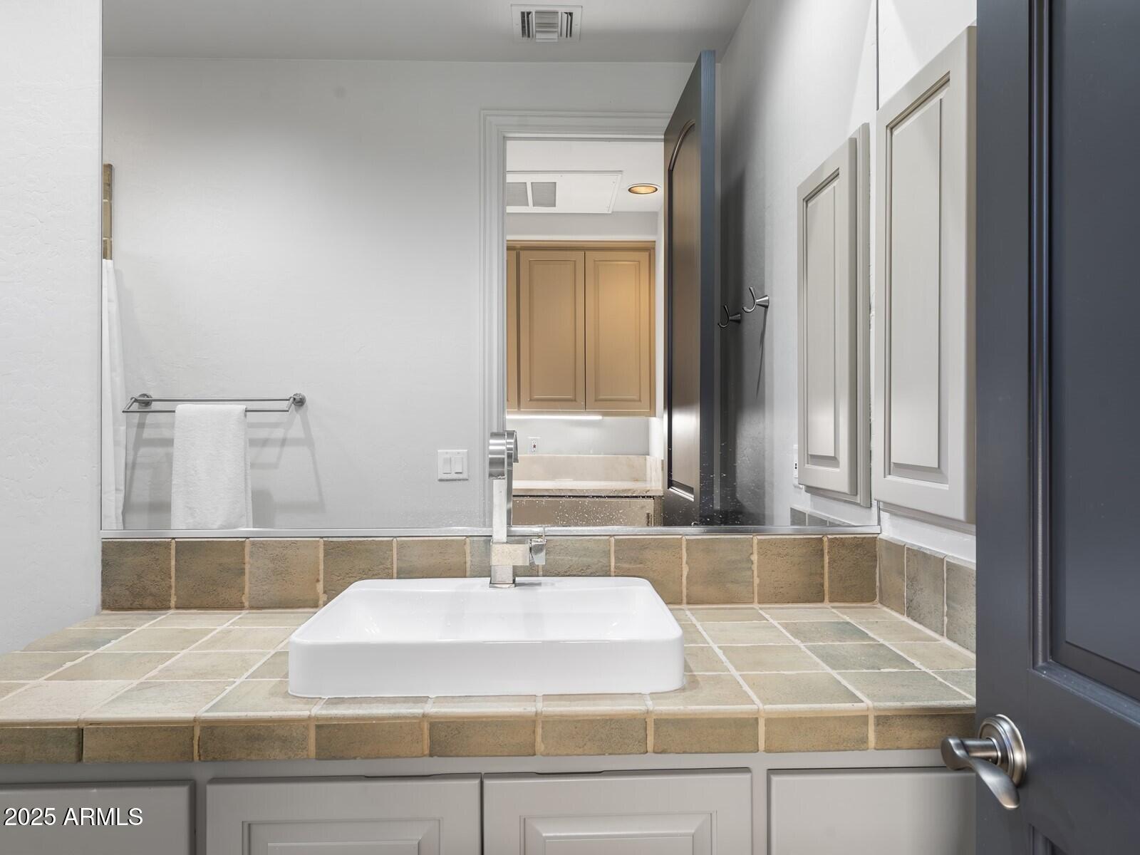 9290 East Thompson Peak Parkway, Unit 142 Scottsdale, AZ 85255 - Photo 63 of 74 a bathroom with a sink and a mirror