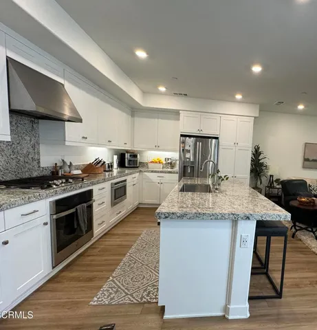 a kitchen with kitchen island granite countertop wooden cabinets and a stove