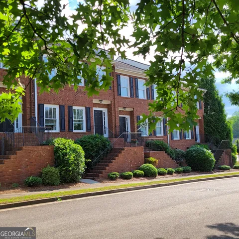 a front view of a house with a garden and plants