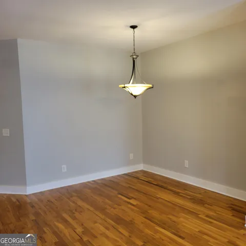 a view of empty room with window and wooden floor