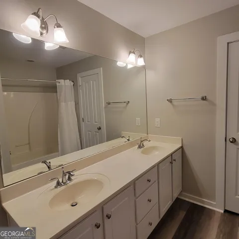 a bathroom with double vanity sink and a mirror