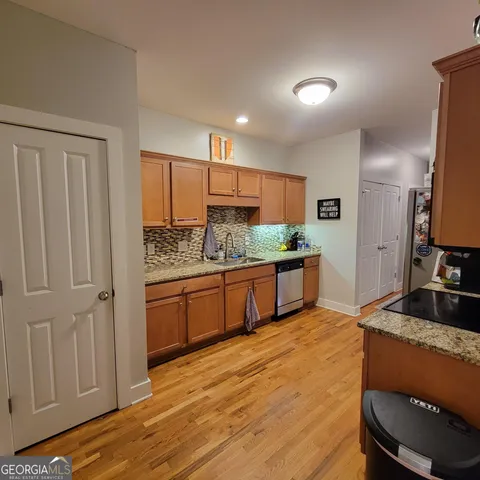 a kitchen with stainless steel appliances granite countertop a stove a sink and a refrigerator