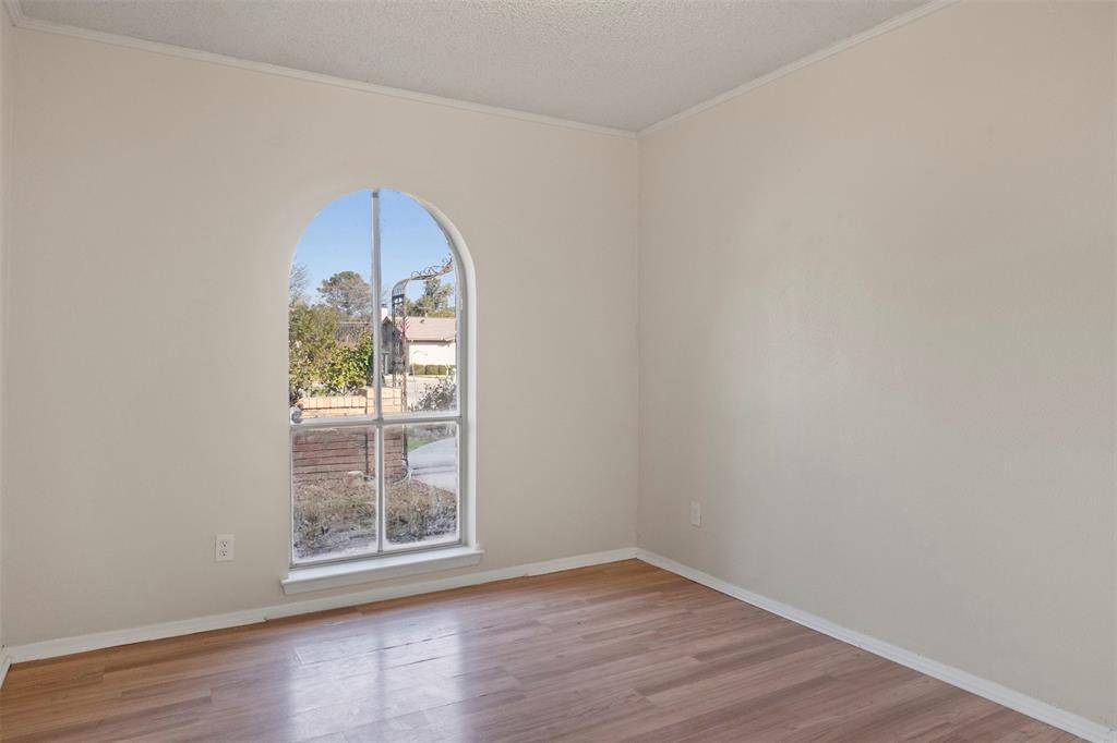 3718 West Rochelle Road Irving, TX 75062 - Photo 12 of 29 an empty room with wooden floor and a window