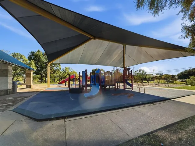 a view of a patio with a table and chairs under an umbrella