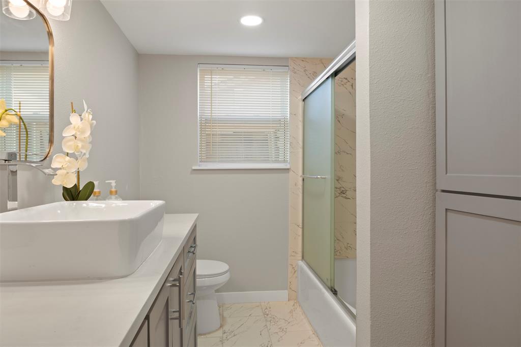 3718 West Rochelle Road Irving, TX 75062 - Photo 17 of 29 a bathroom with a sink mirror vanity and toilet