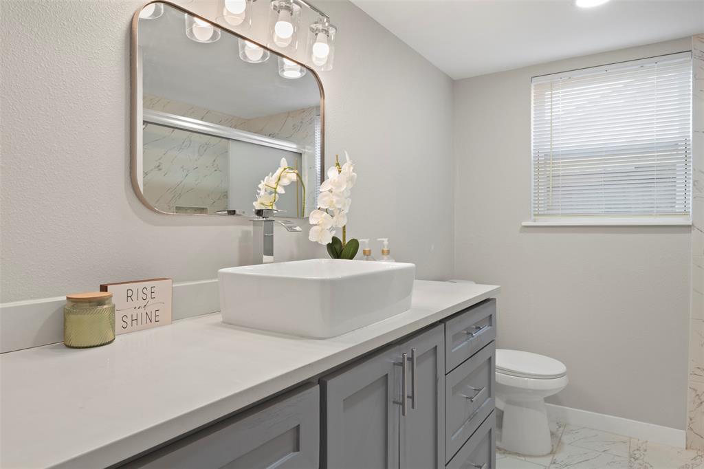 3718 West Rochelle Road Irving, TX 75062 - Photo 19 of 29 a bathroom with a sink a toilet and mirror