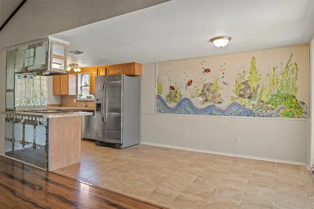 a kitchen with stainless steel appliances a refrigerator and a stove top oven
