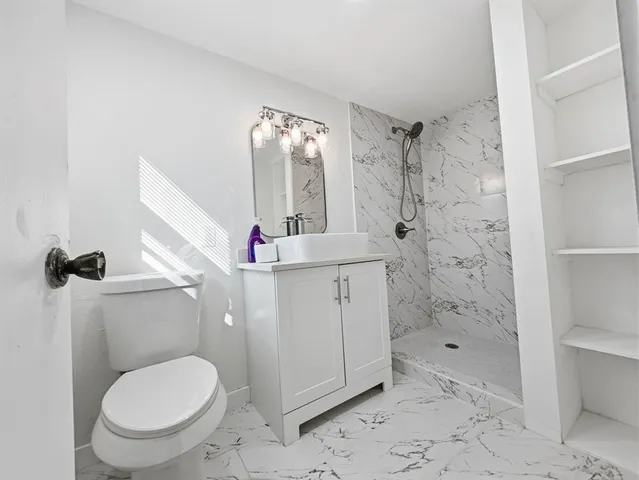 a bathroom with a sink toilet and shower