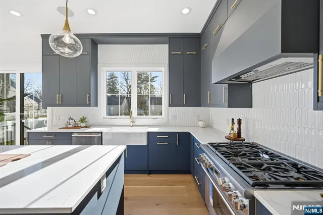 a large kitchen with stainless steel appliances granite countertop a stove and a sink